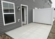 Thumbnail 16 of 17 - the front door of a grey house with a white garage door